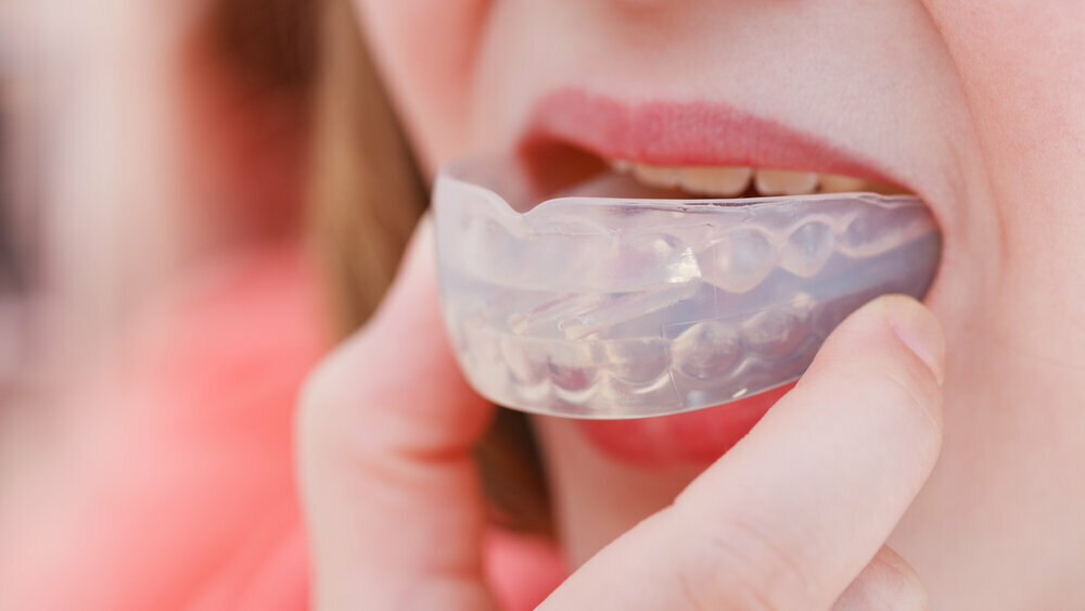 Mouth guard for illuminating early signs of cavities