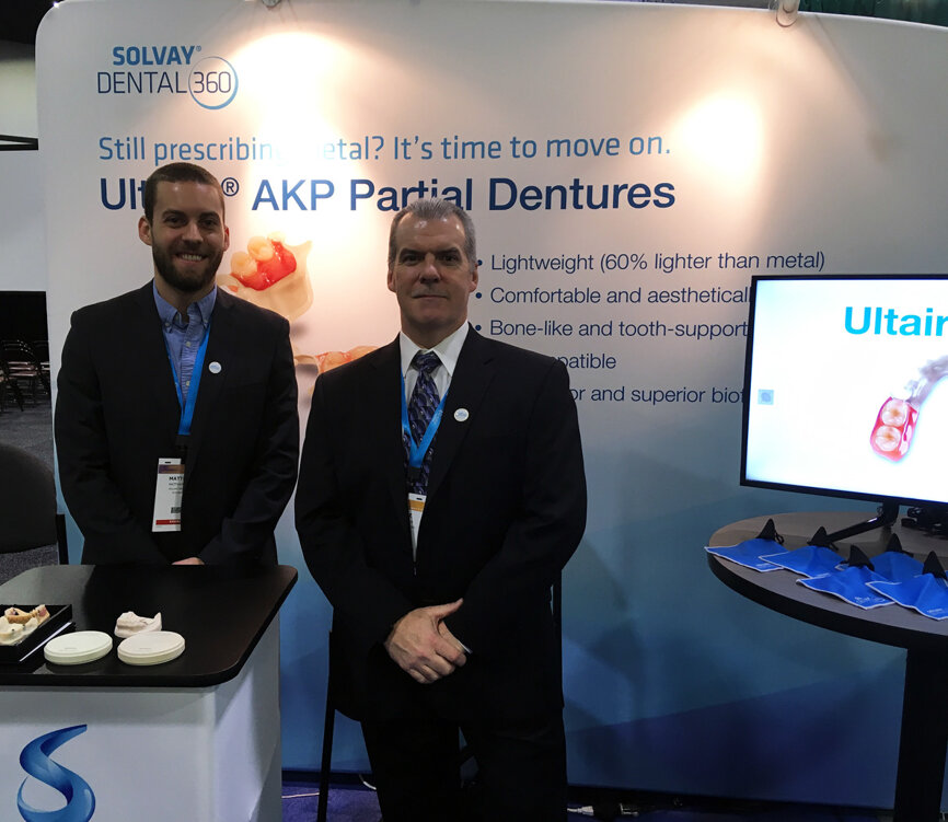 Displaying the innovative Ultaire AKP metal-free removable partial dentures in the Solvay Dental 360 booth are, from left, Matthew Sims and Duane Fish.
