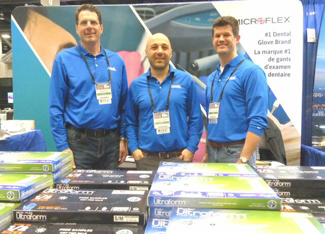 In the Ansell booth, from left: Scott Frail, Evren Baykal and Mike Rogozinski have free samples available of lots of gloves, including the Microtouch Denta-Glove with Ergoform ergonomic design technology.