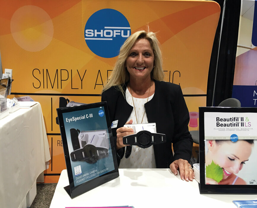 LeAnn MacDonald shows off the EyeSpecial C-III, a digital camera made specifically for dentists, at the Shofu booth.