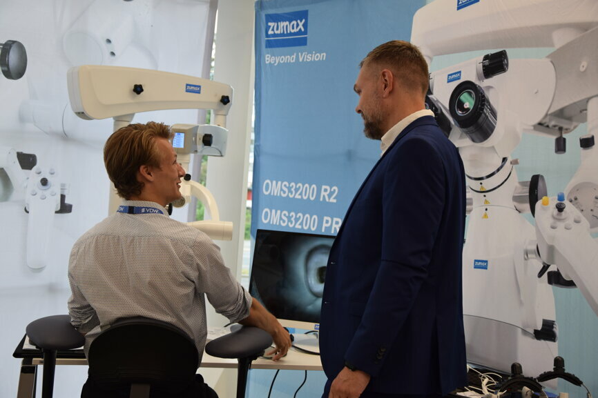 Demonstration of the OMS 3200 dental microscope at the Zumax booth.