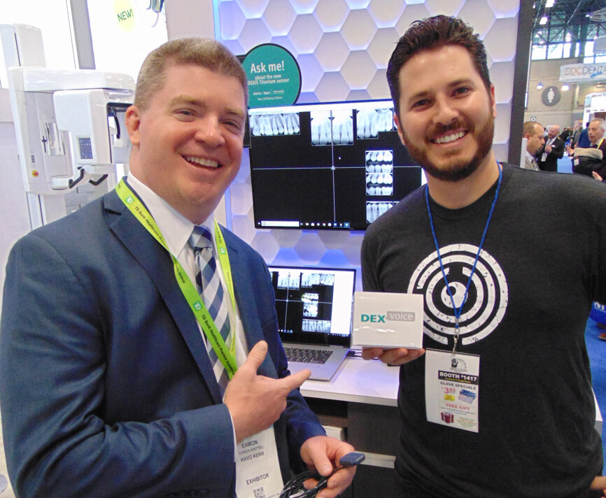 Eamon Knittel, left, and Ryan Hungate show off new sensor technology available from DEXIS at the Kavo Kerr booth. (Photo: Fred Michmershuizen/Dental Tribune America)