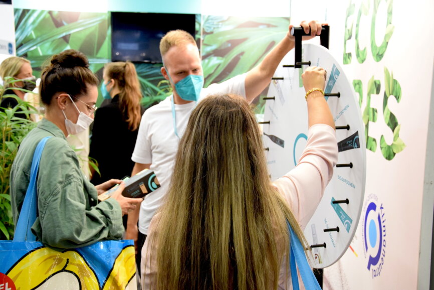 IDS visitors are spinning the wheel of fortune to win oral hygiene products at the happy brush stand. (Image: Dental Tribune International) 
