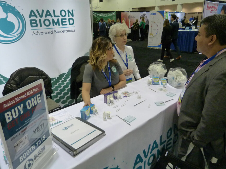 In the Avalon Biomed booth, Hugo Munoz, DDS, of Guatemala City, Guatemala, learns more about NeoMTA Plus after having worked with a sample. Helping him, from left, is Nikki Ruck and Carolyn Primus, PhD. 