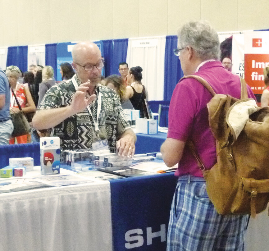 Dan Christensen of Shofu helps an attendee pick out products.