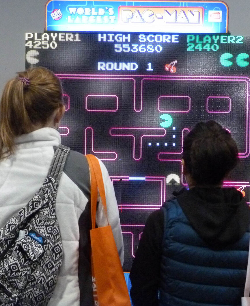 Attendees play the World’s Largest Pac-Man in the ’80 Arcade area sponsored by Peebles Prosthetics.