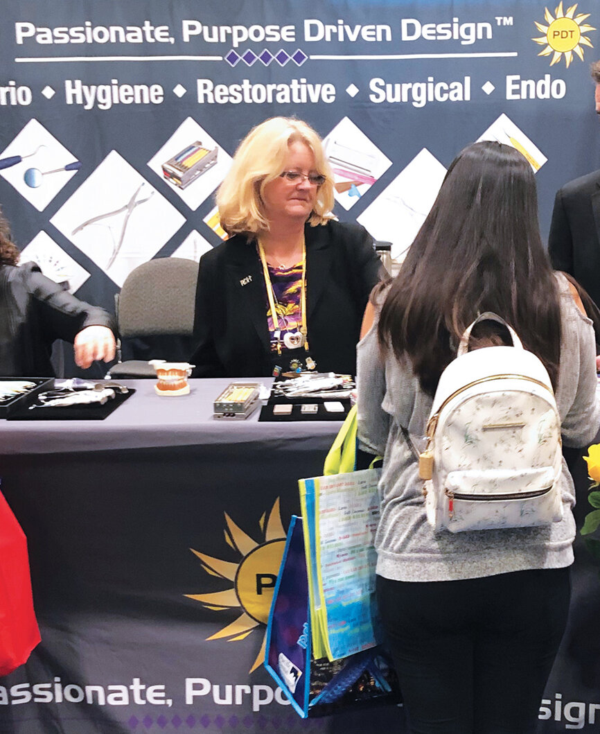 Wendy Birtles helps an attendee in the  Pacific Dental Technologies booth.