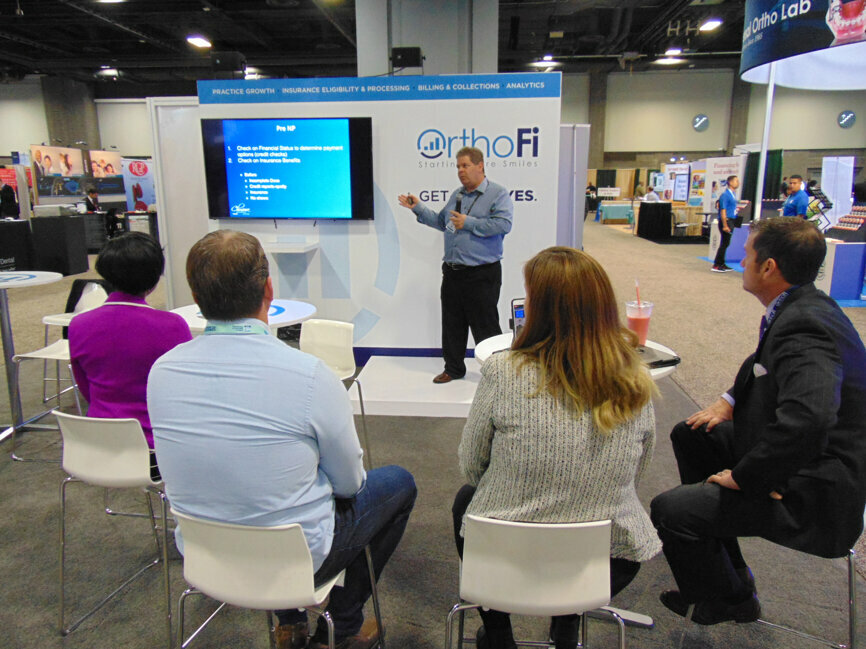 Orthodontic professionals attend a presentation by Dr. Lou Chmura at OrthoFi, one of many companies offering educational opportunities in the exhibit hall.