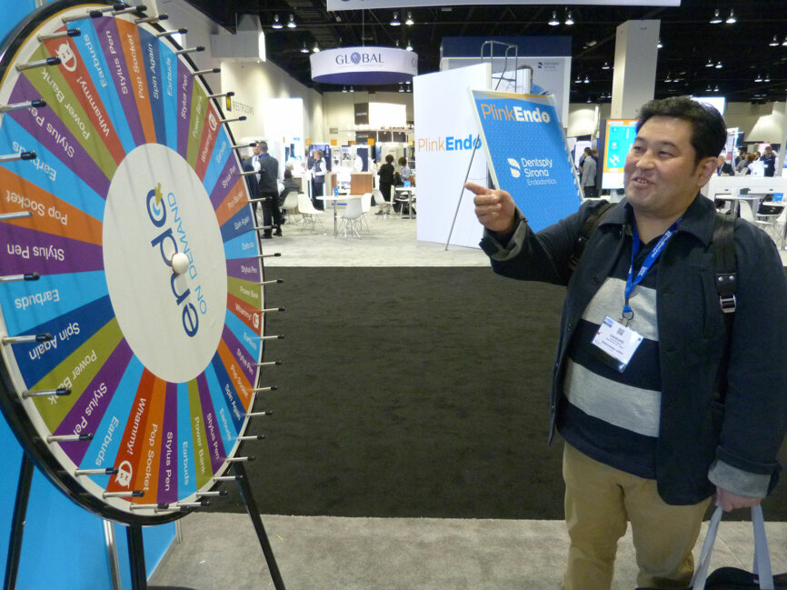 In the AAE Attendee Lounge, Daisuke Nagao, DDS, of Hitachinaka City, Japan, waits for the prize wheel to stop spinning (his prize: a pair of earbuds).