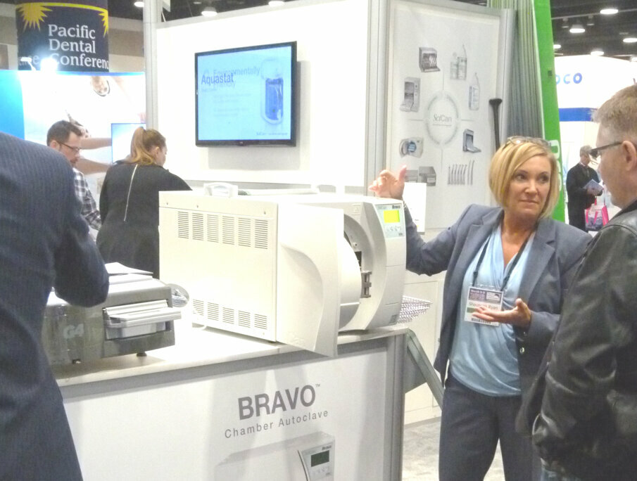 In the SciCan booth, Shauneen Ryan demonstrates one of the company’s BRAVO chamber autoclaves. Its closed-door drying and post-vacuum technology speeds up drying time compared with other chamber autoclaves.