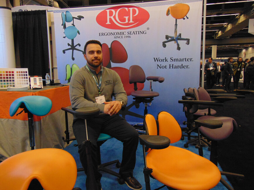 Jason DeCosta of RGP, a company showcasing ergonomically designed chairs with special arm supports for endodontists. (Photo: Fred Michmershuizen/Dental Tribune America)