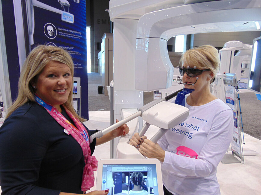 Jennifer Horwath, left, and Kyle Hansen demonstrate the new Planmeca Viso imaging system, making its debut at AAOMS 2018. (Photo by Fred Michmershuizen/Dental Tribune USA)