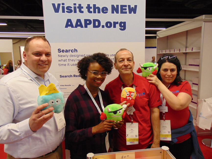 From left: Dr. Joshua Durrant of Cleveland Heights, Ohio; Dr. Tasha Batts of Detroit; and AAPD staff members Bob Gillmeister and Adriana Loaiza show off some of the Mouth Monsters available for purchase at the AAPD store. (Photo by Fred Michmershuizen/Dental Tribune America)