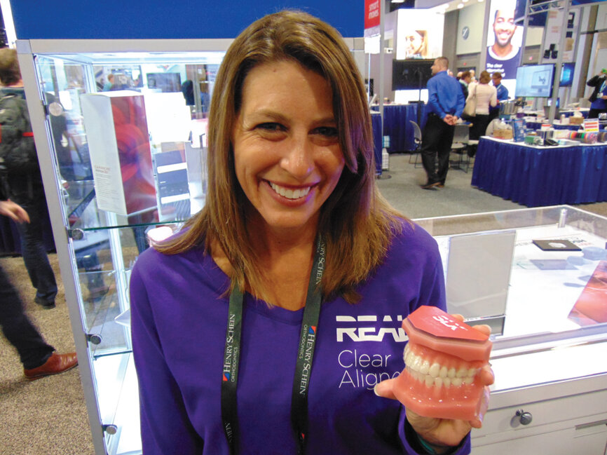 Tanya Wulkowicz of Henry Schein Orthodontics holds a model displaying the company’s new SLX Clear Aligners. 