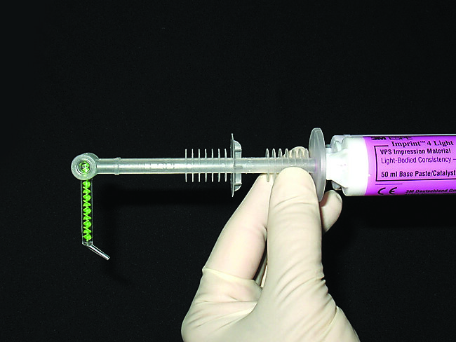 Fig. 6. 3M Imprint 4 Light is placed from the 3M Garant Dispenser into a 3M Intraoral Syringe, and the tip can be directed for precise application