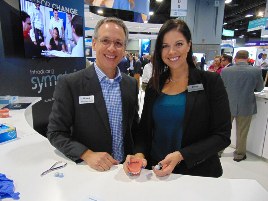 Brett Kowald, left, and Suzanne Wilson of Ormco demonstrate the company’s new Symetri Clear brackets.