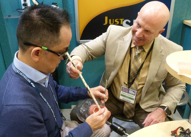 Marty O’Rourke, right, of Designs for Vision, helps Dr. Hansel Liang of Surrey try out a pair of Nike Skylon Ace 2.5-magnification loupes, which use the Through-The-Lens magnification technology invented by the company.